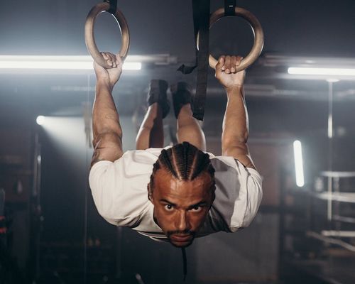 Athletic man demonstrating balance and core strength in a gym.