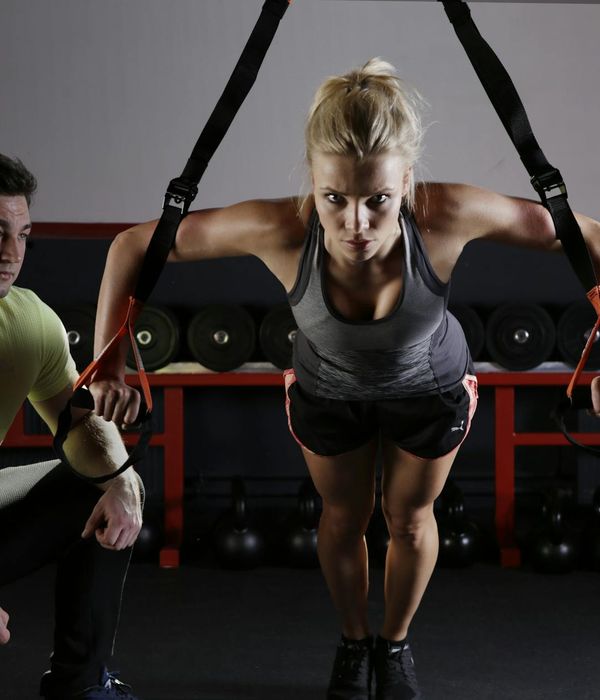 Strong man performing a powerful functional training movement in dark gym.